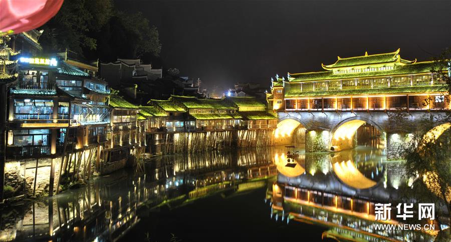 En hiver, la scne nocturne du village antique de Fenghuang, dans la province du Hunan (centre de la Chine), attire gnralement de nombreux touristes, qui viennent admirer les illuminations colores installes pour l'occasion.