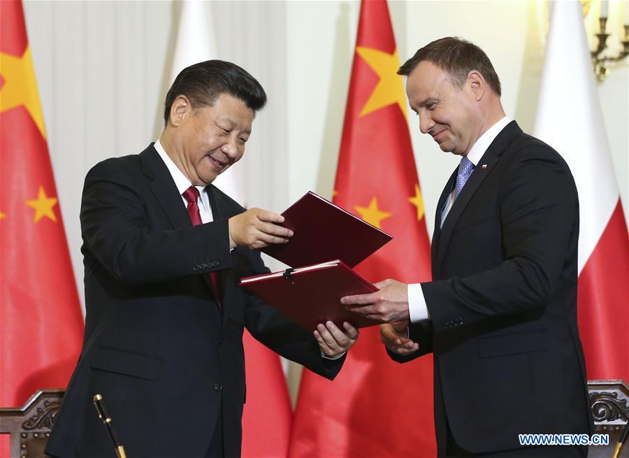 Le président chinois Xi Jinping et son homologue polonais Andrzej Duda signent un communiqué conjoint à l'issue de leur entretien à Varsovie, en Pologne, le 20 juin 2016. (Xinhua/Lan Hongguang)