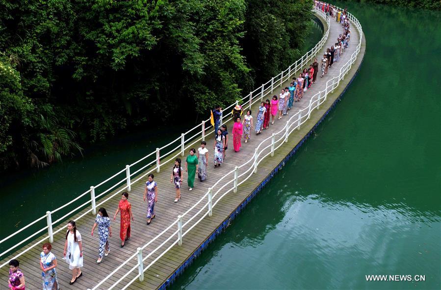 Femmes vêtues des robes chinoises classiques marchant sur un chemin en planches  