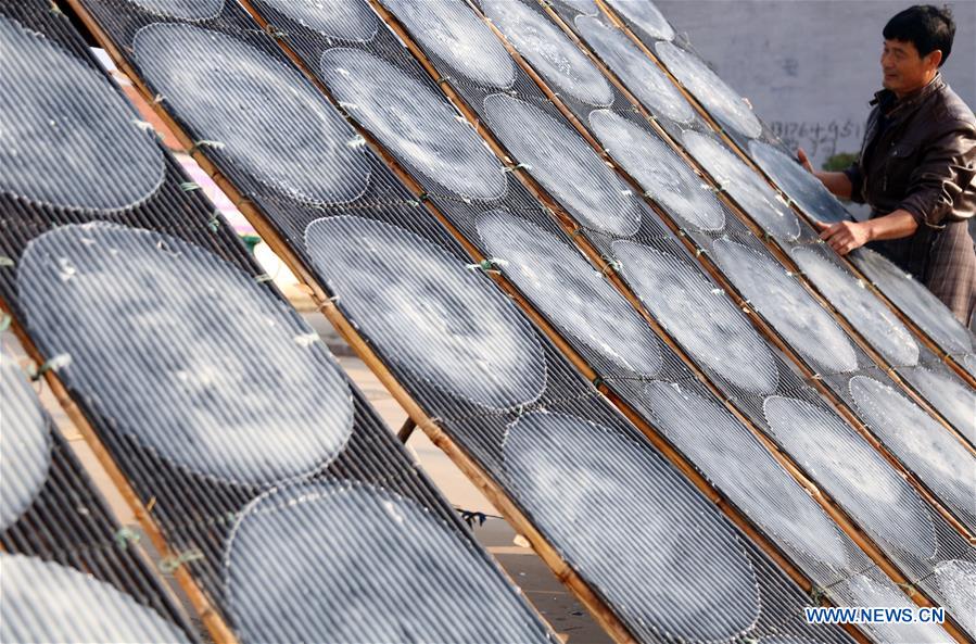 Chine : paysan séchant de la gelée d'amidon de patate douce