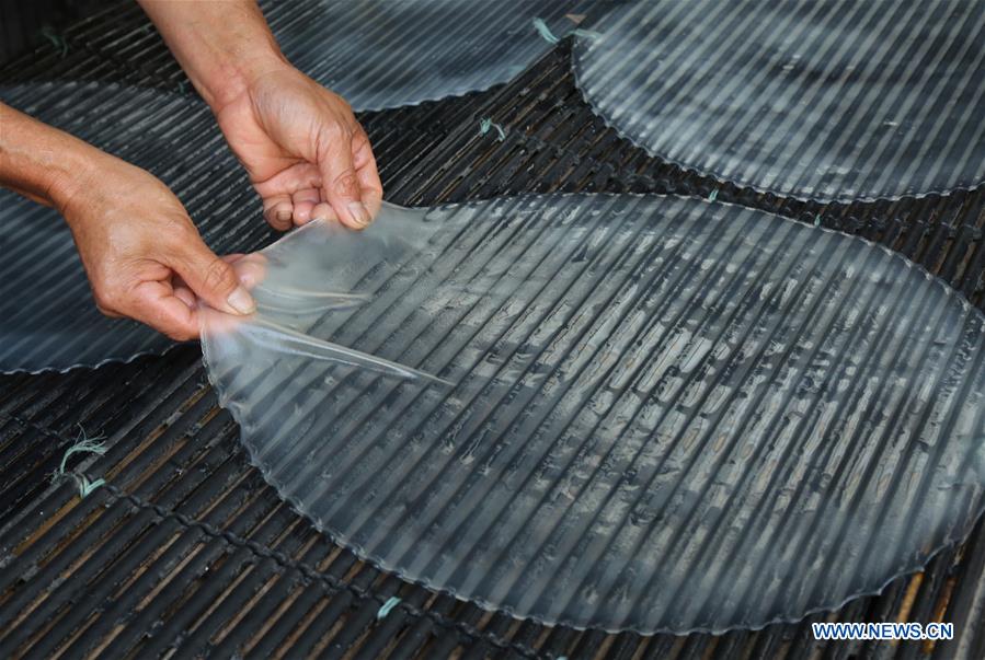 Chine : paysan séchant de la gelée d'amidon de patate douce