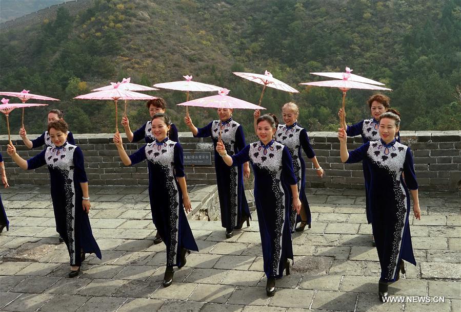 Chine : défilé de femmes en qipao sur la Grande Muraille