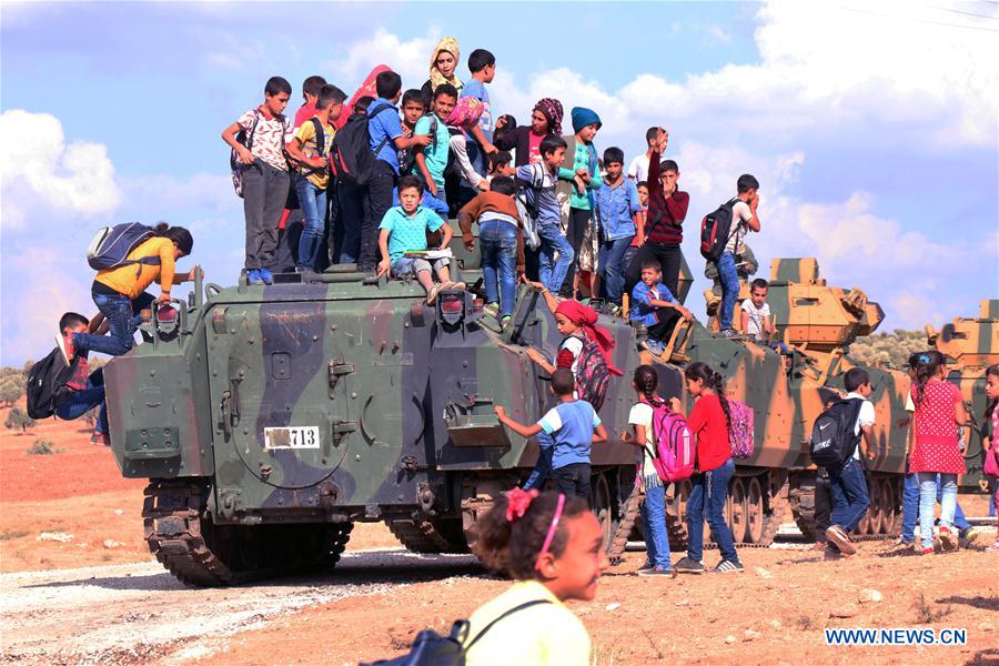 Des enfants sur un véhicule militaire turc