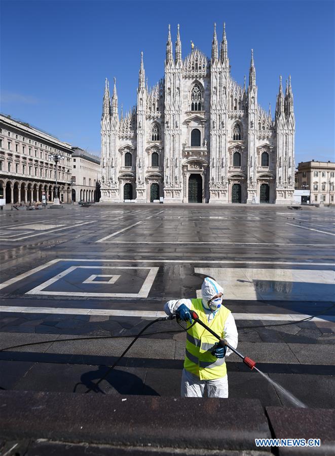 Un travailleur désinfecte la rue à Milan en Italie