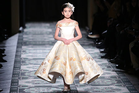 Un petit mannequin Xiuqiu, une neuf-ans fille chinoise, défile à Paris