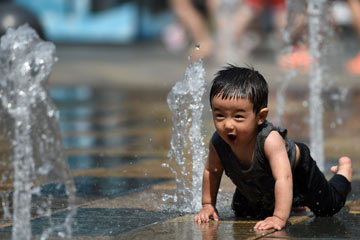 Des enfants jouent avec l'eau pour éviter la chaleur à Beijing