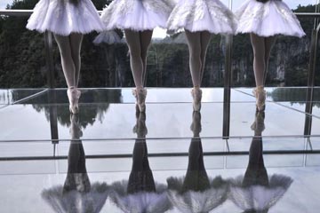 Des danseurs de ballet dansent sur la plate-forme en verre au sommet d'une falaise à Chongqing