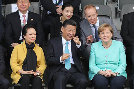 Xi Jinping et Angela Merkel assistent à un match de football amical entre des équipes 
junior chinoise et allemande