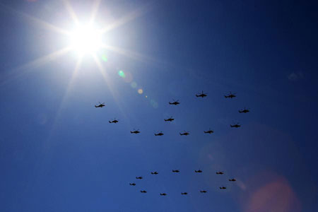 Des hélicoptères volent en formation durant le défilé