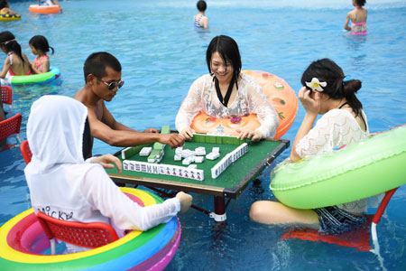 Des gens jouent au mah-jong dans une piscine pour se rafraîchir à Chongqing