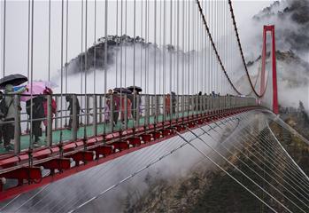 En promenade sur le pont suspendu pour piétons des monts Yimeng